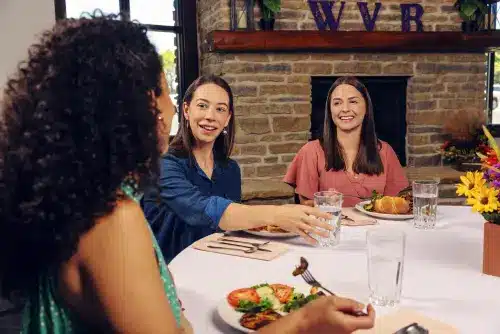 Women enjoying a meal and conversation at Wood Violet Recovery.